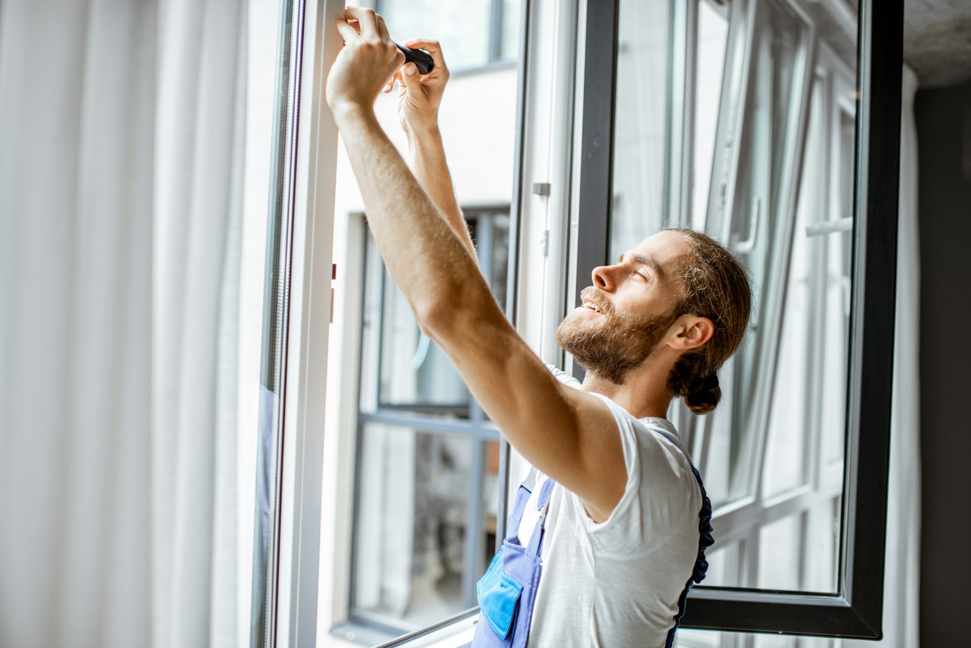 Workman adjusting window frames at home